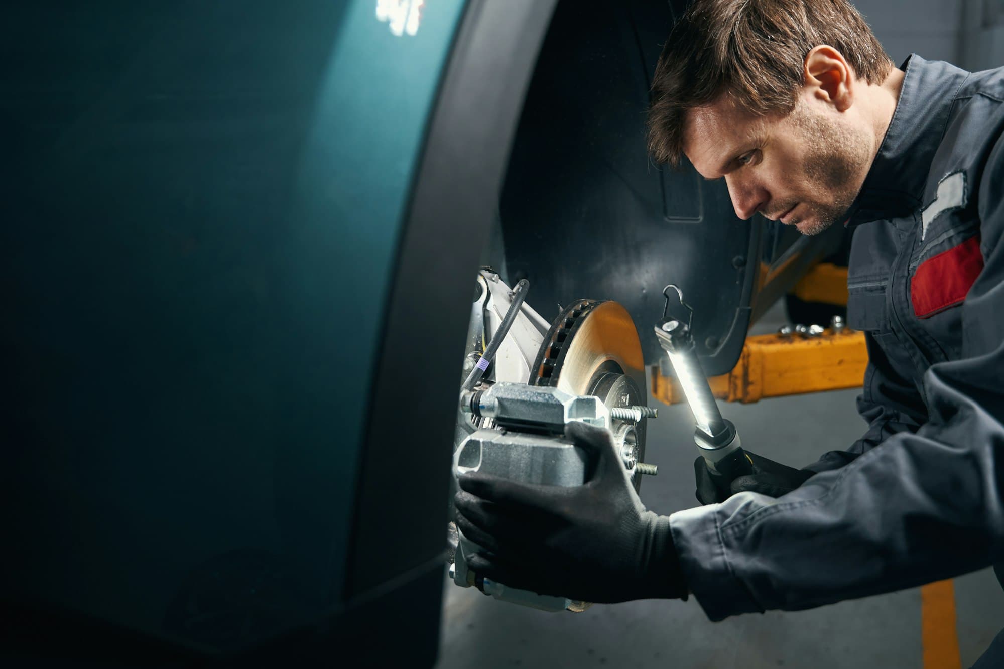 Technician inspecting a vehicle brake system