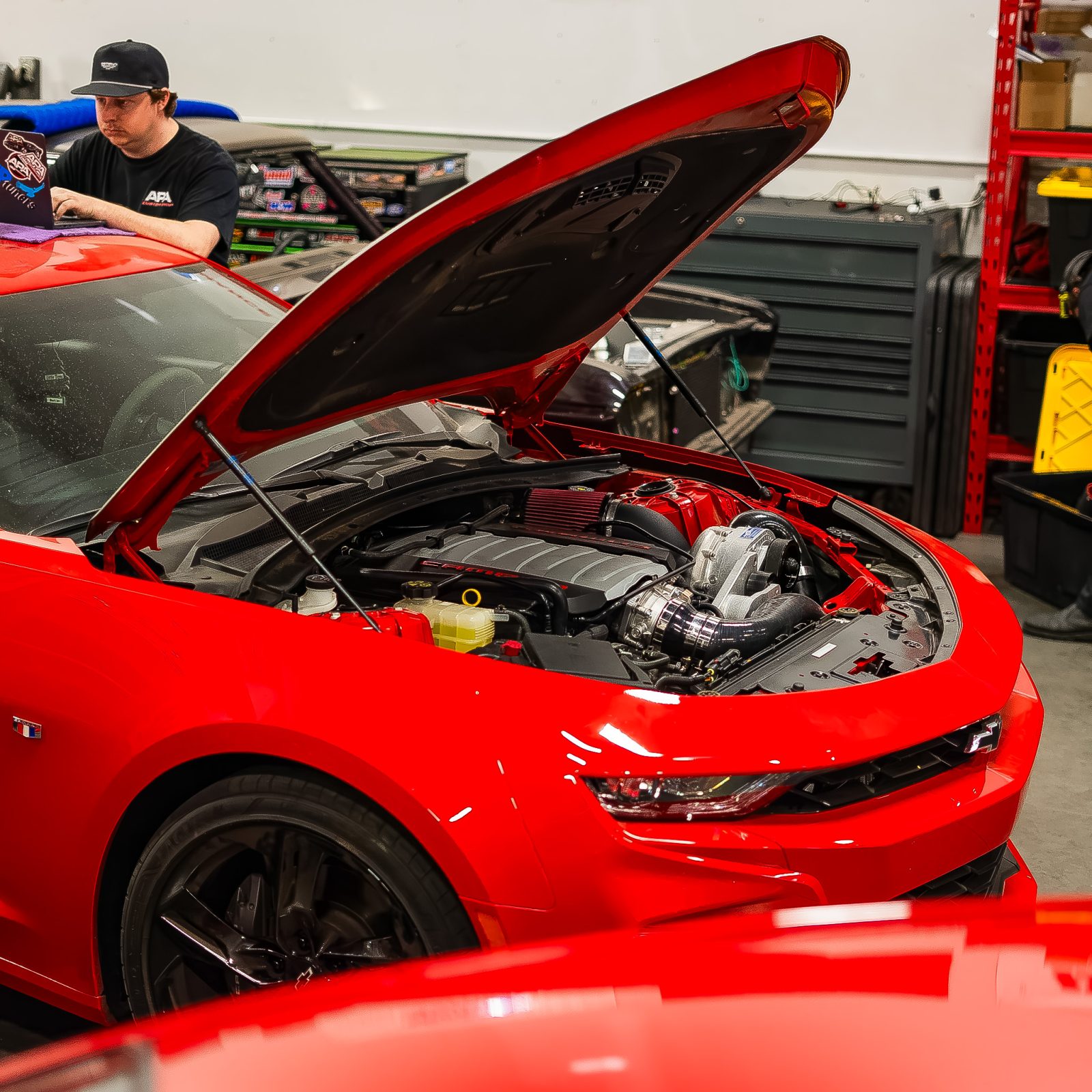 Tuner reviewing data logs on red Camaro